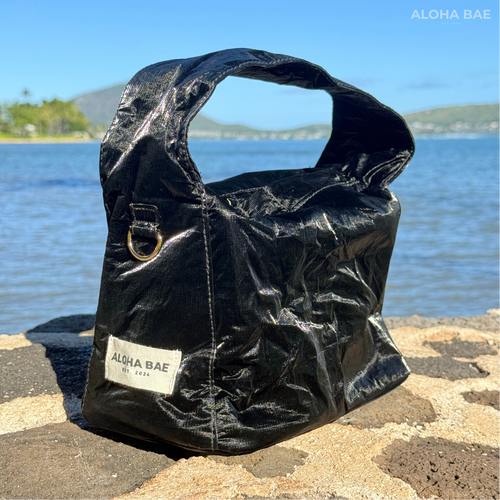 A black sheen hobo bag by alohabae with a slouchy design and shoulder strap, featuring smooth, shiny material.