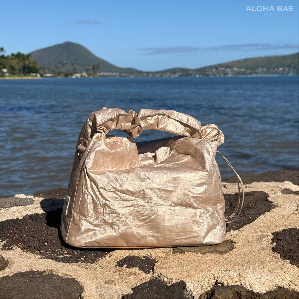 Aloha Bae champagne-colored hobo bag with a soft, slouchy design and shoulder strap, featuring stylish details and a smooth finish.