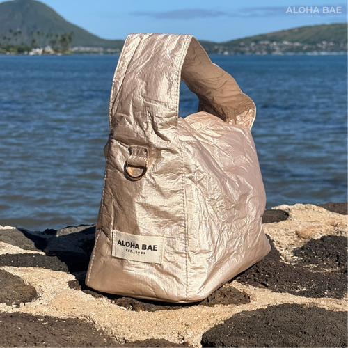 Aloha Bae champagne gold hobo bag with a sleek design, featuring a shoulder strap and stylish metallic finish.