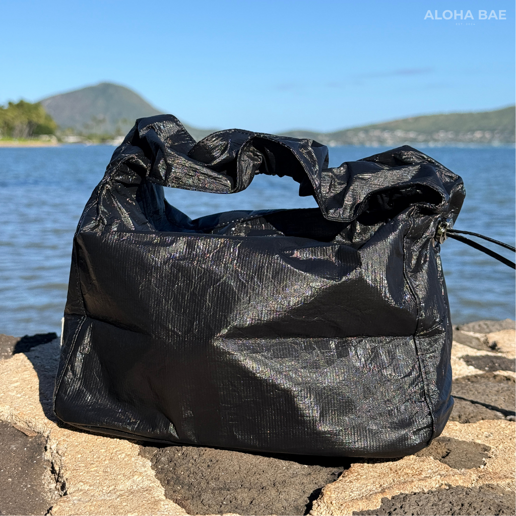 Aloha Bae matte black hobo bag with adjustable strap and minimal design, featuring the brand logo on the front.