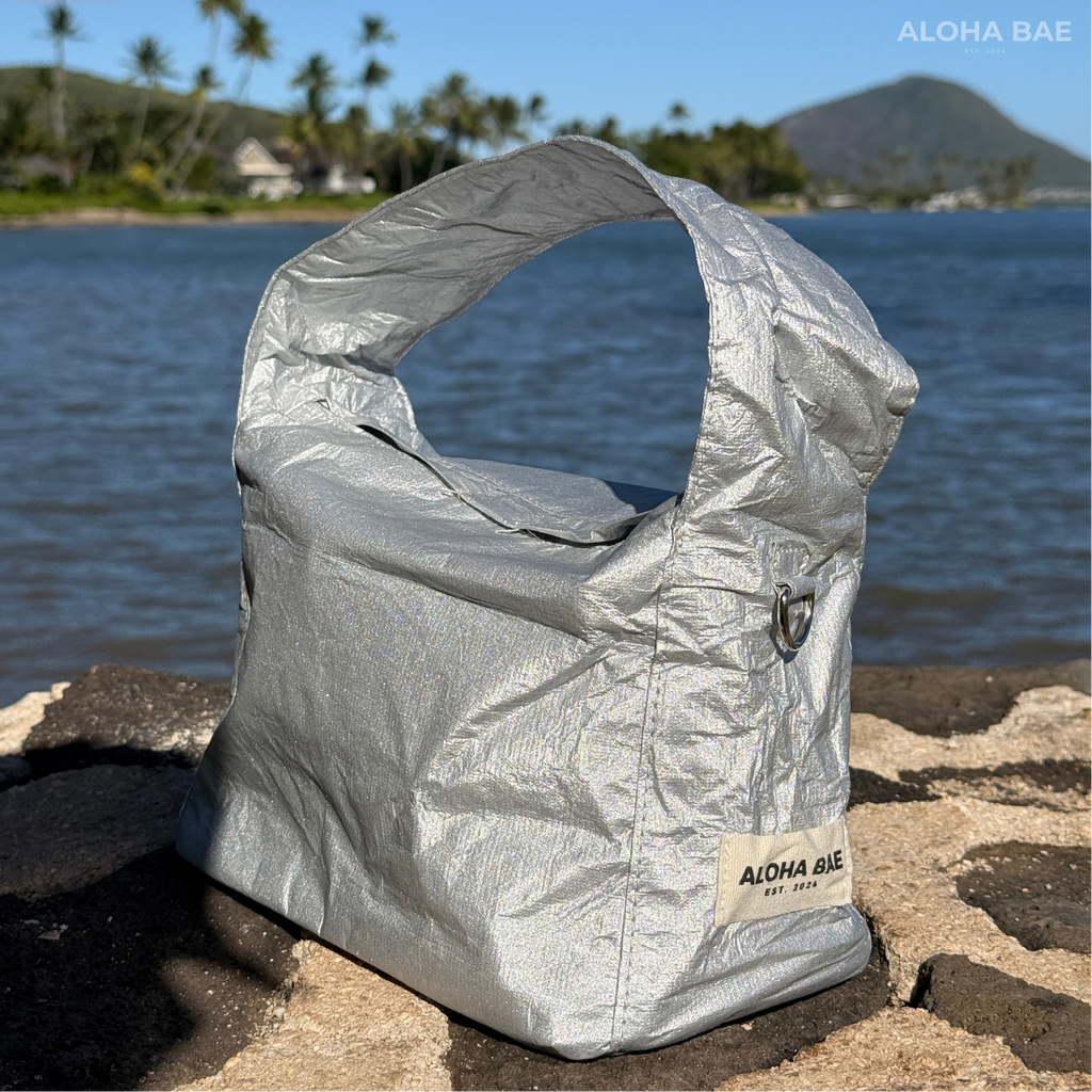 Silver Aloha Bae hobo bag with a slouchy design and shoulder strap, featuring a stylish and casual look.