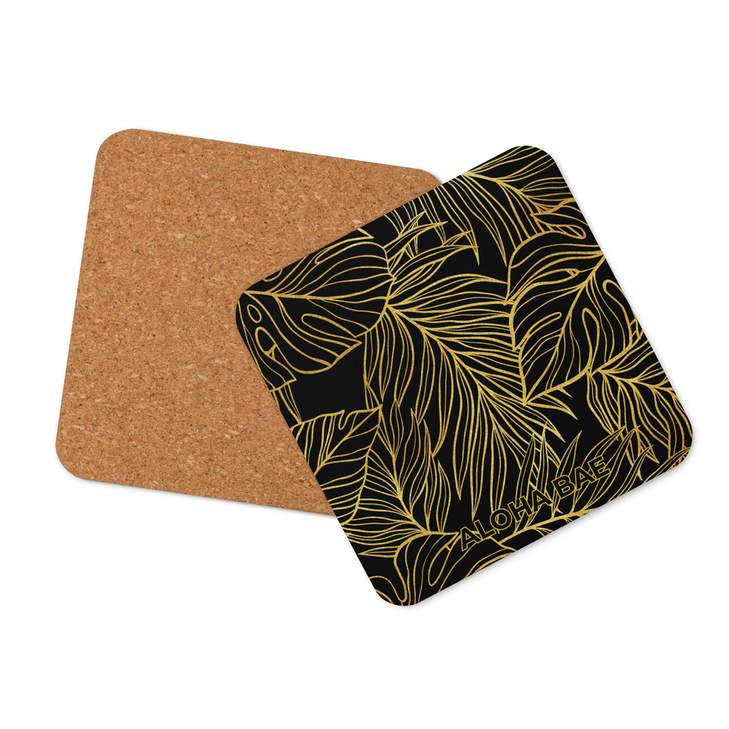 A black and gold monstera design cork-back drink coaster with a natural cork surface and decorative monstera leaf pattern.